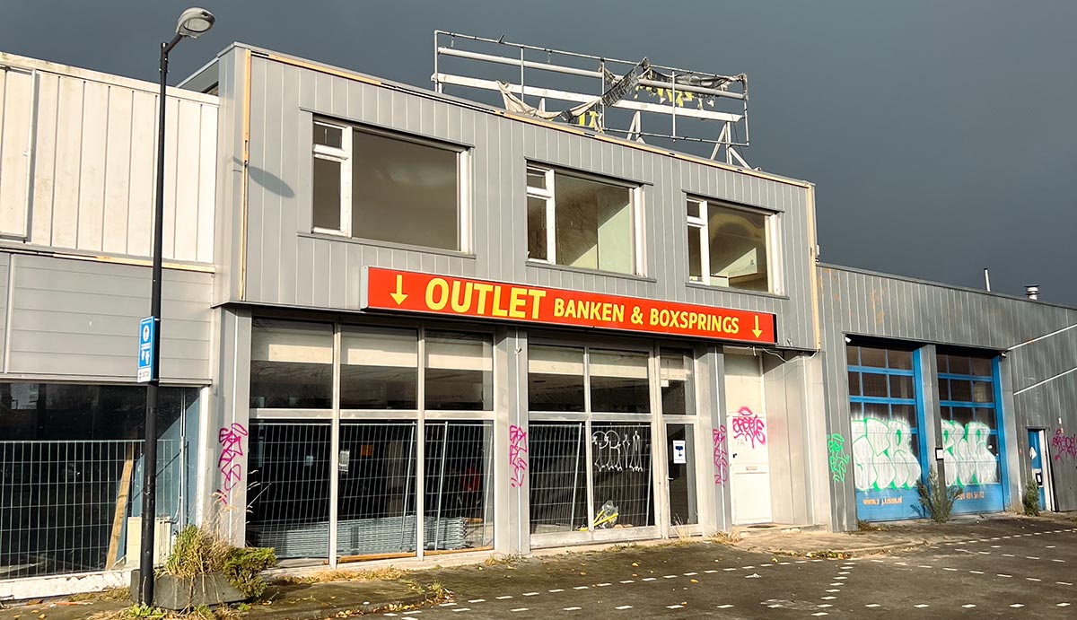 Photo of facade of empty discount mattress store about to be demolished